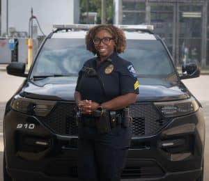 Female sergeant in front of police patrol vehicle